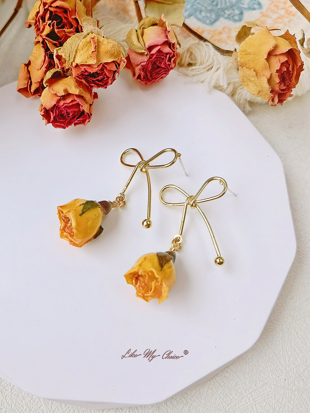 Orecchini con fiori secchi e fiocco di rosa