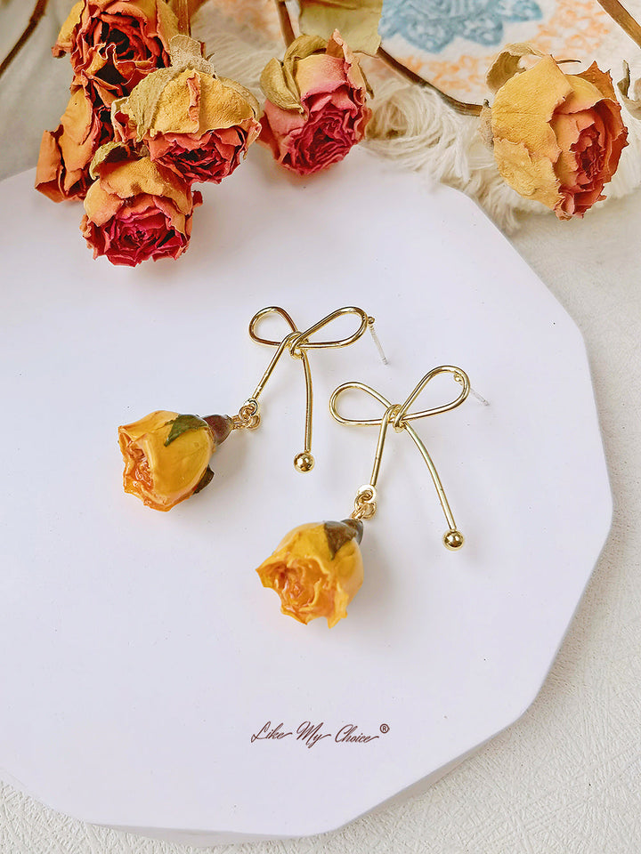 Orecchini con fiori secchi e fiocco di rosa