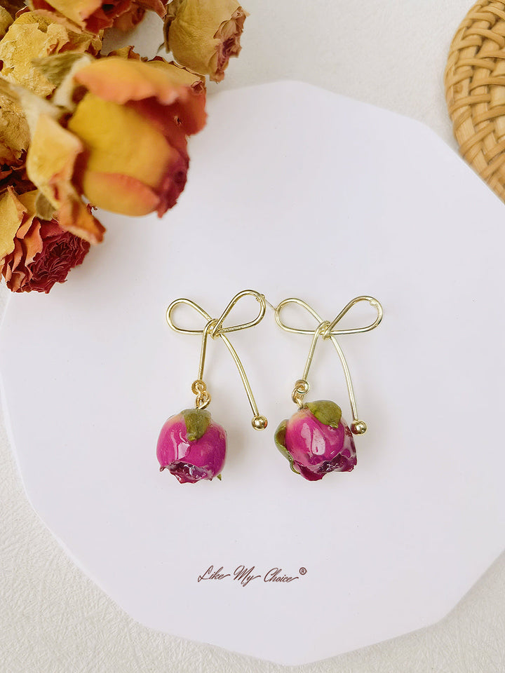 Orecchini con fiori secchi e fiocco di rosa