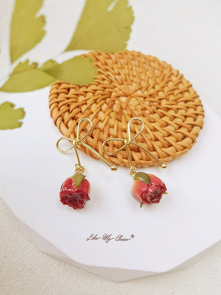 Orecchini con fiori secchi e fiocco di rosa
