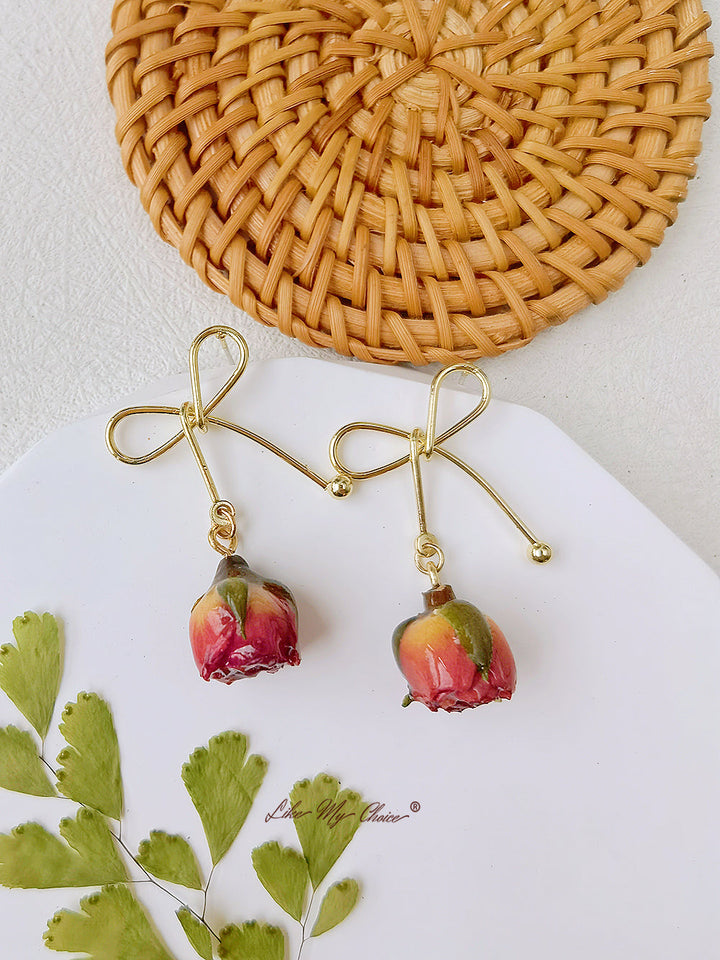 Orecchini con fiori secchi e fiocco di rosa