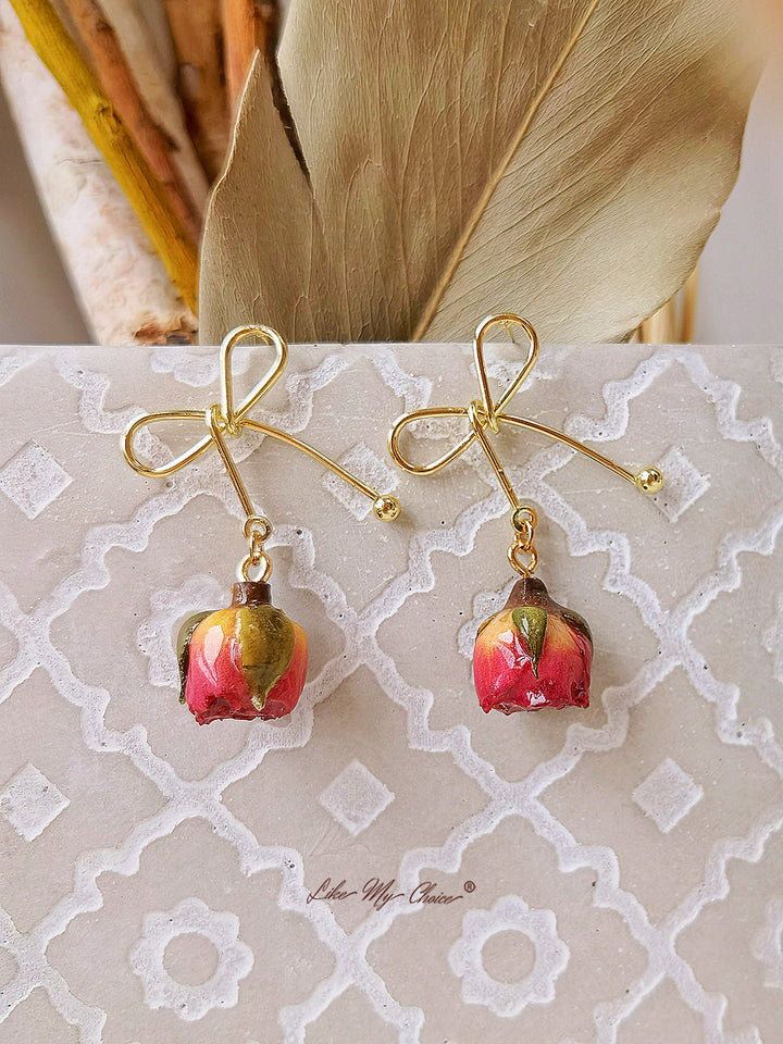 Orecchini con fiori secchi e fiocco di rosa