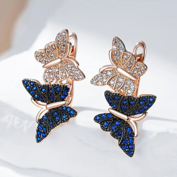 Orecchini pendenti con due farfalle in zircone naturale blu placcato oro rosa 18K